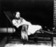 China: A young woman with bound feet reclining on a chaise longue, c.1890